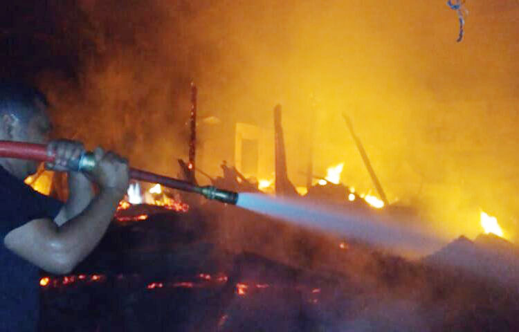 2 Rumah Kayu Ludes Dilahap si Jago Merah, Satu Orang Alami Luka Bakar 1 KEBAKARAN— Petugas Damkar berusaha memadamkan api dengan menyemprotkan air.