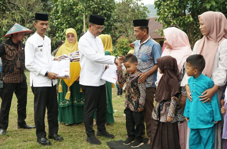 BAGIKAN—Bupati Solok Selatan H. Khairunas saat bagikan  seragam gratis di Kecamatan Sangir Jujuan di SMP N 17 Solok Selatan, Jumat (25/8).