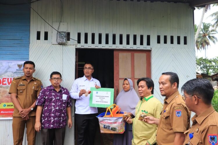 SERAHKAN BANTUAN— Pj Wali Kota Payakumbuh bersama Ketua Baznas Kota Payakumbuh Edi Kusmana menyerahkan bantuan usaha kepada keluarga kurang mampu.