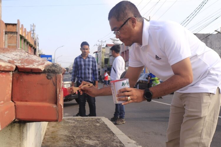 CAT JEMBATAN—Pj. Wali Kota Rida Ananda terlibat langsung  bekerja mencat Jembatan Ratapan Ibu.