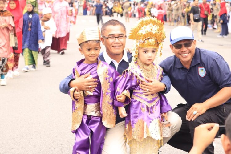 FOTO BERSAMA— Pj Wali Kota foto bersama dua anak yang semangat ikut pawai alegoris.