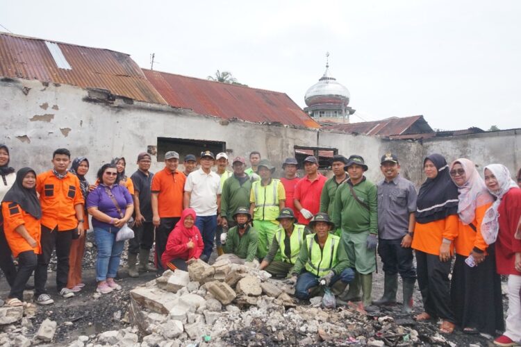 BERSIHKAN—Pj.Wali Kota Payakumbuh saat membersihkan puing-puing sisa kebakaran bersama warga dan dinas terkait