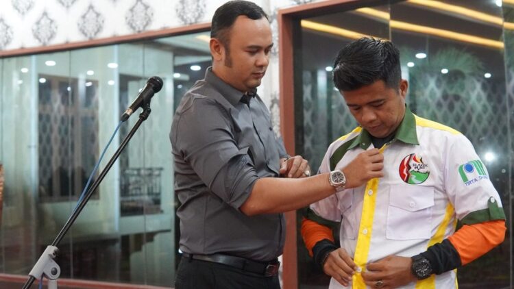 PAKAIKAN—Bupati Sijunjung Benny Dwifa pakaian baju pada salahseorang anggota.