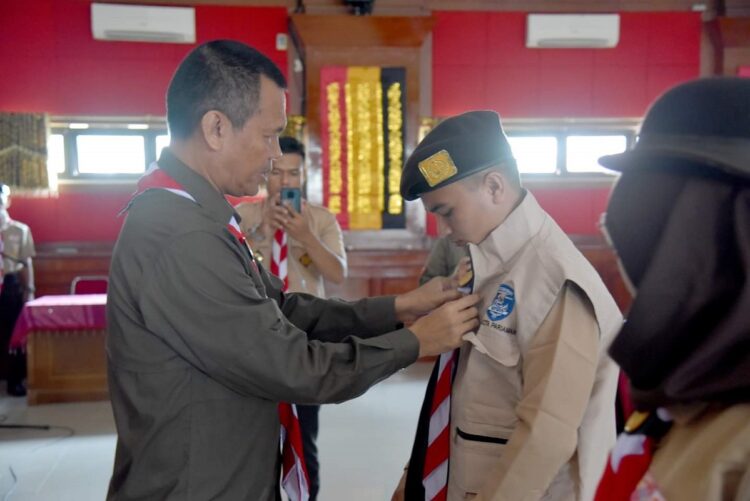 PASANGKAN JAKET— Wali Kota Pariaman H Genius Umar  memasangkan jaket anggota pramuka saat pelepasan menuju Raimuna Nasional di Cibubur..