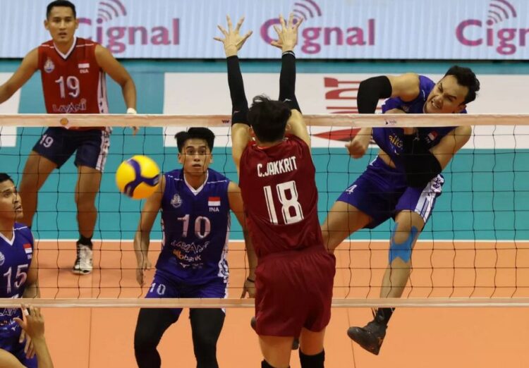 LEPASKAN SMASH— Pemain timnas Hendra Kurniawan (kanan) melepaskan smash ke area pertahanan Thailand di laga terakhir SEA V League, Minggu (30/7).