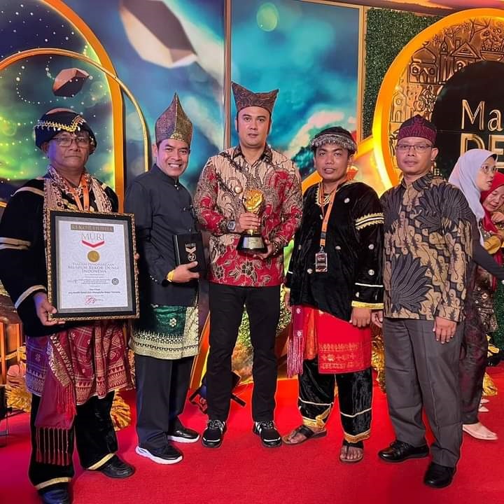 REKOR MURI—Bupati Sinjunjung Benny Dwifa didampingi Kadis Parpora, Afrineldi dan Walinagari Sijunjung, Rajilis saat menerima penghargaan dari Kementrian Pariwisata dan Ekonomi Kreatif.