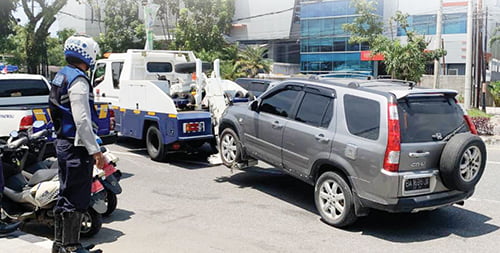 Parkir di Bahu Jalan Kawasan Tertib Lalulintas, Dishub Tilang 4 Mobil, 1 Diderek 1 DEREK MOBIL— Petugas Dishub Kota Padang melakukan penderekan satu unit mobil yang parkir di jalan Khatib Sulaiman, Selasa (26/9) pagi. Sebelumnya, petugas sudah memberi toleransi 10 menit untuk menunggu pemilik untuk memindahkan kendaraannya tersebut, namun tak kunjung datang.