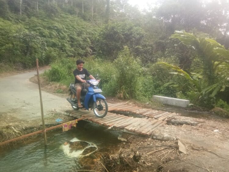 Pasca Putus, Masyarakat Swadaya Bangun Jembatan dengan Kayu 1 MELINTAS— Masyarakat saat melintasi jembatan kayu yang dibangun swadaya oleh masyarakat.