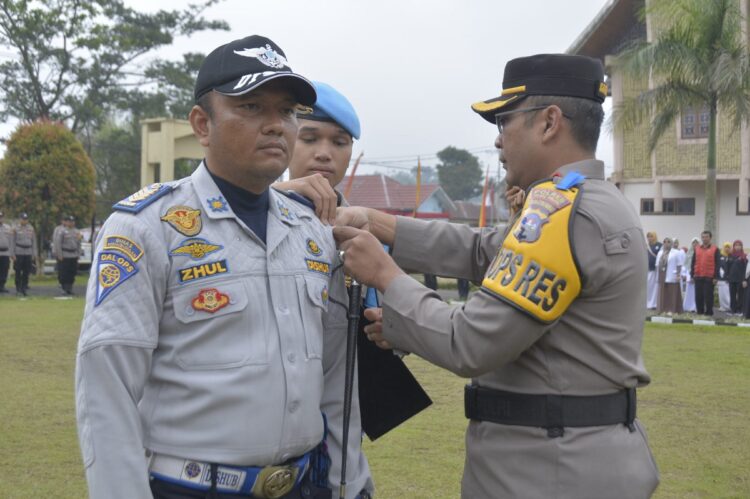 APEL PASUKAN OPERASI ZEBRA SINGGALANG— Kapolres Padang Panjang, AKBP. Donny Bramanto, SIK pasangkan pita kepada personel Dishub usai apel gelar pasukan Operasi Zebra Singgalang 2023 di halaman Mapolres, Senin (4/9).