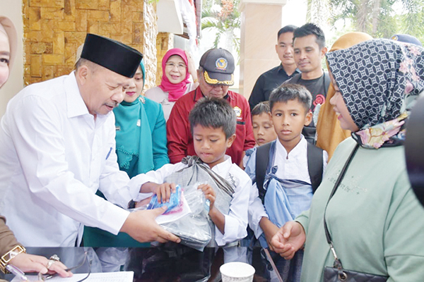 SERAHKAN BINGKISAN— Bupati Agam memberikan bingkisan kepada anak-anak yang mengikuti khitanan massal program Indojalito Peduli, Selasa (5/9), di Mess Pemkab Agam Belakang Balok, Bukittinggi.