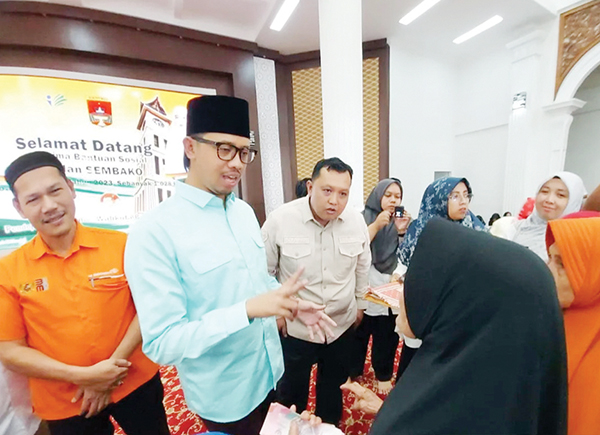 SALURKAN BANTUAN— Walikota Bukittinggi Erman Safar bekerjasama denagan PT Pos Indonesia menyalurkan bansos PKH kepada warga yang membutuhkan.