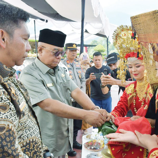 FESTIVAL DANAU MANINJAU— Sekretaris Daerah Kabupaten Agam Edi Busti, menerima siriah dalam carano saat menghadiri pembukaan Festival Pesona Danau Maninjau di Linggai Park, Jumat (1/9).
