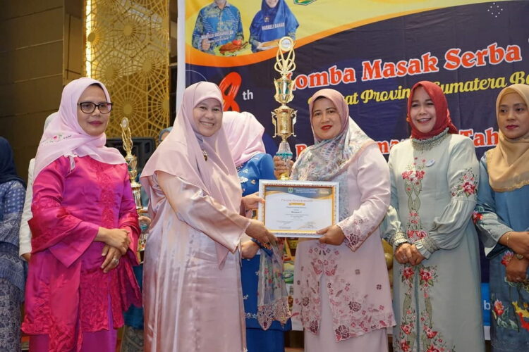 SERAHKAN PIALA— Ketua TP PKK Sumbar Ny Harneli Mahyeldi serahkan hadiah kepada Ny Yusrita Suhatri Bur, usai acara  lomba masak serba ikan tingkat Provinsi Sumatera Barat.