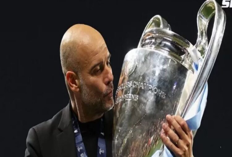 CIUM TROFI— Pep Guardiola mencium trofi UCL yang diraihnya bersama Manchester City musim lalu.