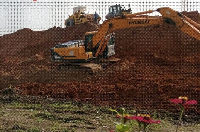 TURUNKAN ALAT BERAT— Satu unit alat berat ekskavator sedang membersihkan tumpukan tanah bekas galian yang terletak pada sisi pembangunan jalan tol.