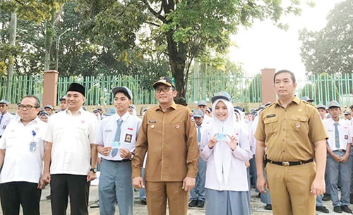 TERIMA E-KTP— Wako Padang Hendri Septa menyerahkan sebanyak 15 e-KTP kepada siswa dan siswi SMA Semen Padang usai bertindak sebagai pembina upacara di lapangan SMA Semen Padang, Senin (16/10).