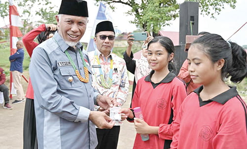 GUBERNUR Sumbar, Mahyeldi Ansharullah menyerahkan suplemen dan vitamin kepada pelajar saat pencanangan Aksi Bergizi di Sekolah di Kepulauan Mentawai.