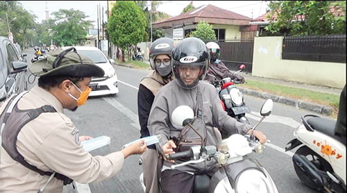 PEMBAGIAN MASKER— Petugas BPBD Kota Padang membagikan masker kepada masyarakat di kawasan Pasar Alai, Kamis (5/10).