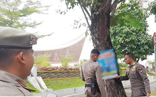 Iklan-iklan Gratis di Pohon dan Tiang Listrik Ditertibkan 1 PENERTIBAN IKLAN— Petugas Satpol PP mencopot sejumlah iklan-iklan yang dipasang di pohon dan tiang listrik di sejumlah jalan di Kota Padang, Kamis (5/10).
