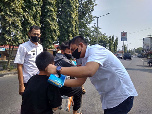 Karang Taruna Bagi-bagi Masker, Kualitas Udara Mulai Memburuk 1 BAGIKAN MASKER— Ainul Farhan J, bersama Lurah Padang Tongah Balai Nan Duo memasangkan masker kepada anak-anak yang melintas di jalan Soekarno Hatta-Payakumbuh