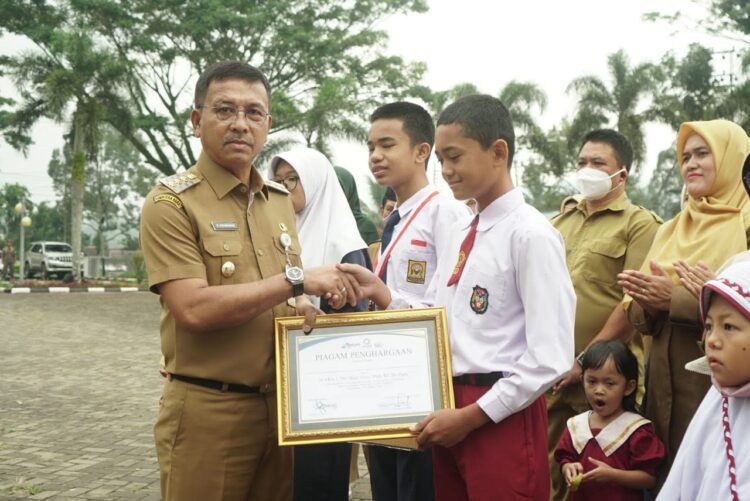 Pemkab Solsel Lakukan Pemetaan dan Uji Kompetensi ASN 1 SERAHKAN PIAGAM— Bupati Solok Selatan Khairunas serahkan piagam pada murid SDN usai apel pagi di halaman kantor bupati Solok Selatan, Senin (16/10).