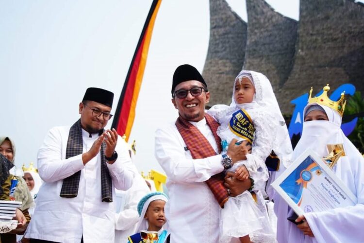 GENDONG HAFIZAH— Bupati Tanahdatar Eka Putra menggendong seorang peserta hafizh saat kegiatan Wakaf 1000 Hafizh, Minggu (8/10) di halaman Istano Basa Pagaruyung.