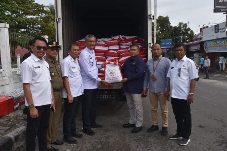 Presiden Batal Datang ke Kota Pariaman, 500 Paket Sembako dari Presiden Dinikmati Masyarakat 1 SERAHKAN PEKT SEMBAKO— Pj Wali Kota Pariaman, Roberia, menyerahkan paket bantuan dari Presiden pada masyarakat.