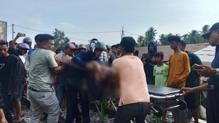Pejalan Kaki Tewas Terserempet Kereta Api 1 EVAKUASI— Warga mengevakuasi korban Dani (62) yan tewas terserempet kereta api di Korong Kasai, Kecamatan Batang Anai, Kabupaten Padangpariaman,