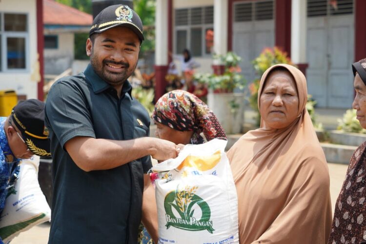 BANTUAN PANGAN— Ketua Dewan Perwakilan Rakyat Daerah (DPRD) Solok Selatan, Zigo Rolanda, serahkan bantuan beras kepada warga tak mampu.