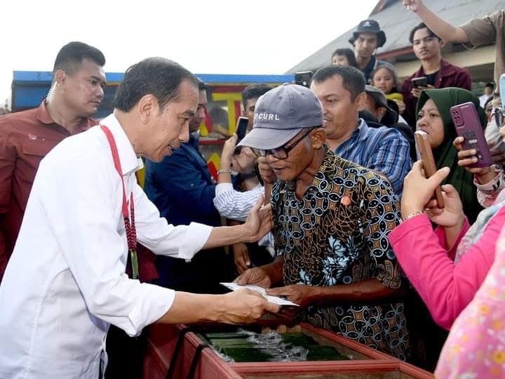 Jokowi Bagi-bagi Kaos dan Sembako di Pasar Ibu Mentawai 1 BERIKAN BMT— Presiden RI Joko Widodo memberikan bantuan dan Bantuan Modal Kerja (BMK) sebesar Rp1,2 juta kepada sejumlah pedagang Pasar Ibu Mentawai dan Bantuan Langsung Tunai (BLT) minyak goreng kepada pedagang.