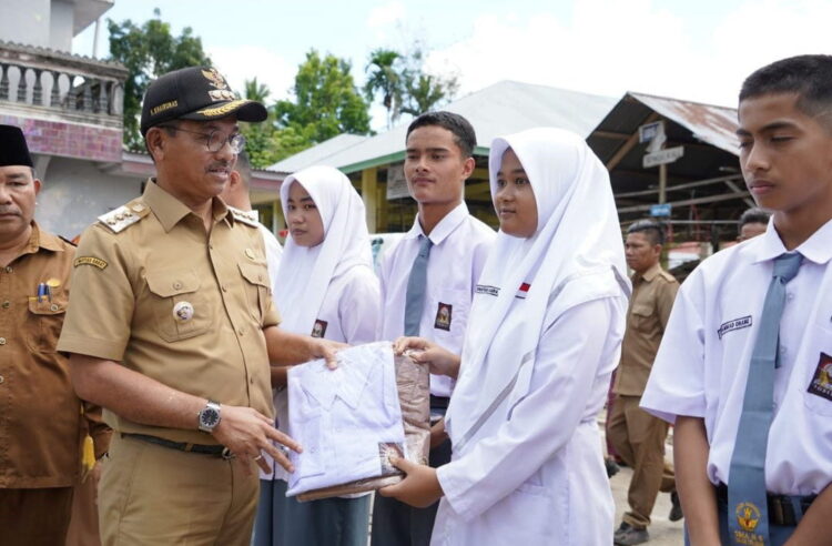 Pemkab Minta Camat dan Nagari Aktif Validasi Data Penerima Bantuan 1 SERAHKAN—Bupati Solok Selatan H. Khairunas salurkan bantuan pakaian seragam sekolah gratis bagi Peserta Didik Baru TK, SMA, dan SMK se-Kabupaten Solok Selatan di Kecamatan Koto Parik Gadang Diateh, bertempat di Pasar Sungai Kalu, baru baru ini.