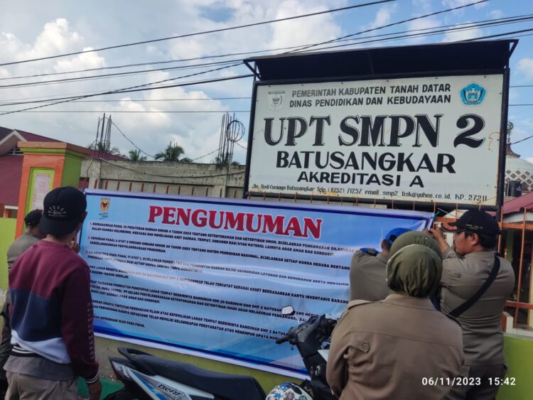 Usai segel dibuka Satpol PP, pemerintah daerah Tanahdatar memasang spanduk pengumuman di pagar sekolah SMP 2 Batusangkar. (chandra antoni)
