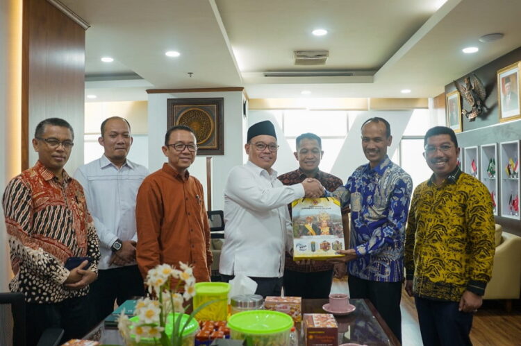 bingkisan— Staf Ahli, Novirman, S.KM, MM serahkan bingkisan kepada perwakilan peserta usai rapat.