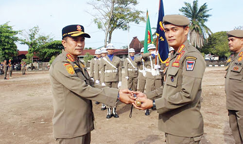 SERTIJAB— Wawako Padang Ekos Albar menyerahkan tongkat komando kepada Kasat Pol PP Chandra Eka Putra, saat menjadi pembina apel serah terima jabatan, Senin (27/11).