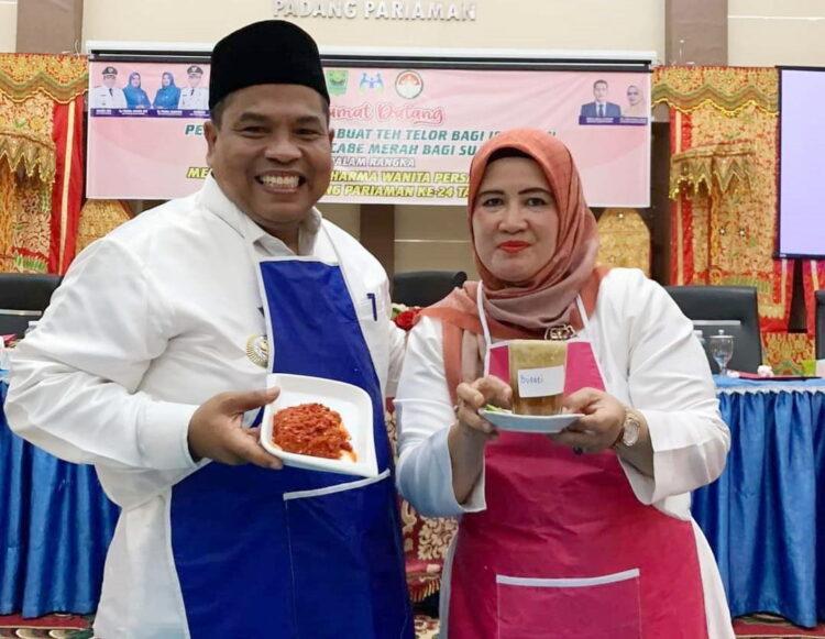 MANGGILIANG CABAI— Bupati padangpariaman Suhatri Bur dan istri, perlihatkan hasil olahan giling cabai dan membuat teh talua, kemarin, saat memeriahkan HUT DWP Padangpariaman ke-24.