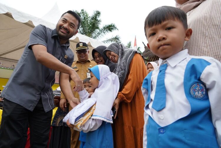 SERAHKAN SERAGAM GRATIS— Ketua DPRD Solok Selatan Zigo Rolanda menyerahkan baju seragam gratis kepada siswa tingkat TK.