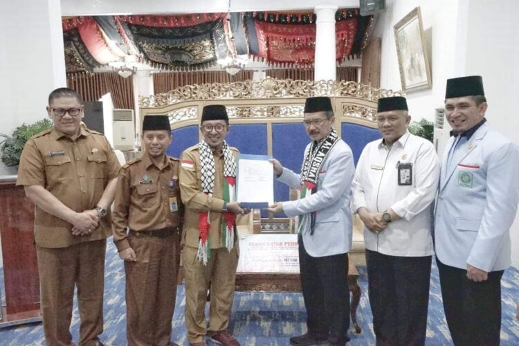 Pemkab Tanah Datar Serahkan Donasi Rp609 Juta untuk Palestina 1 SERAHKAN DONASI— Bupati Tanahdatar Eka Putra serahkan donasi senilai Rp609 untuk umat muslim di Palestina, kepada Wakil Ketua Umum BKPRMI Yeyen Munawar, di gedung Indojolito Batusangkar.