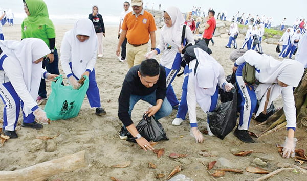AKSI BERSIH PANTAI— Wawako Padang Ekos Albar bersama pelajar SMP 1 Padang melakukan aksi bersih-bersih di Pantai Padang, Sabtu (11/11).