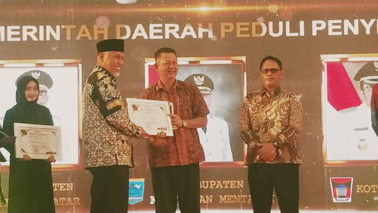 TERIMA PENGHARGAAN— Staf Ahli Ekonomi Pembangunan Tamrin ST, mewakili Bupati Tanahdatar menerima  penghargaan pada Anugrah KPID Sumbar Tahun 2023 yang diserahkan oleh Gubernur Mahyeldi.