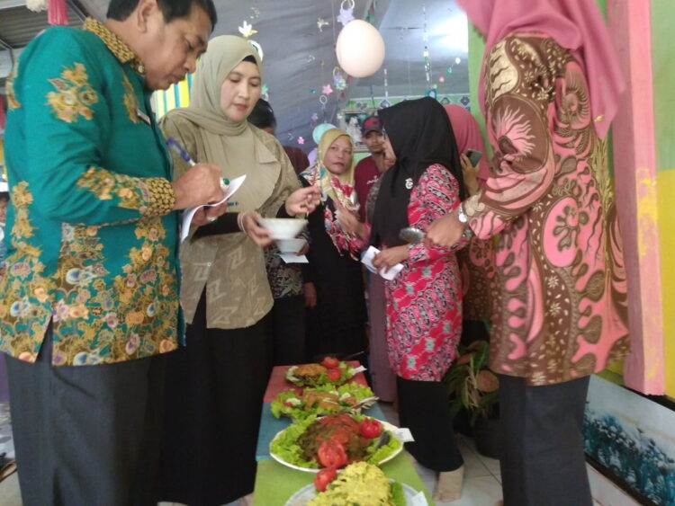 LOMBA MASAK IKAN—Kepala Dinas Kominfo Desri didampingi Istri menilai masakan berbahan ikan.