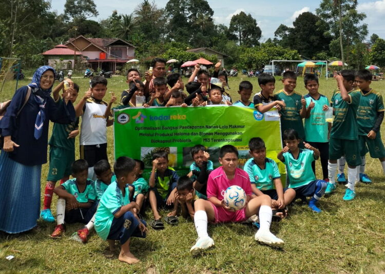 BAGIKAN MINUMAN— Mutia Elida bersama Tim MF Politeknik Pertanian Payakumbuh saat membagikan minuman sehat Bionas kepada anak-anak yang akan main bola di Nagari Halaban