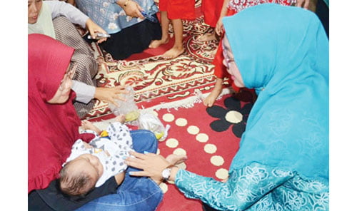 BANTUAN PMT— Ketua TP PKK  Kota Padang Ny. Genny Hendri Septa menyerahkan bantuan pemberian makanan tambahan (PMT) bagi balita di di Posyandu RPCM Terintegrasi BKB dan PAUD Az-Zaitun, Kelurahan Kalumbuk, Kecamatan Kuranji, Kamis (14/12).