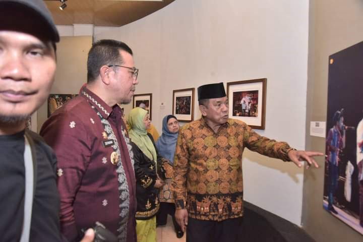 LIHATKAN—PJ Walikota Sawahlunto Zefnihan melihat pameran langsung pameran foto,” Menduniakan Sawahlunto,” 
mengenang sosok Amran Nur.