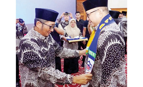 PASANGKAN SELEMPANG— Wako Padang Hendri Septa memasangkan selempang kafilah MTQN kepada Ketua Umum Lembaga Pengembangan Tilawatil Quran (LPTQ) Kota Padang Andree Algamar, saat pelepasan 72 kafilah dan ofisial menuju MTQN Tingkat Sumbar di Solsel, Minggu (10/12).