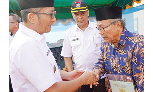 SERAHKAN SERTIFIKAT— Wali Kota Padang Hendri Septa bersama Kepala BPN Kota Padang Alim Bastian, menyerahkan sertifikat melalui Program Redistribusi Tanah, di Jalan Ulu Gadut depan PDAM, Kecamatan Pauh, Rabu (27/12).