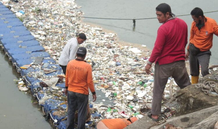 TUMPUKAN SAMPAH— Petugas DLH Kota Padang melakukan pengangkutan sampah yang menumpuk dan tertampung dalam jaring di bantaran banda bakali Taman Siswa (Tamsis), beberapa waktu lalu.