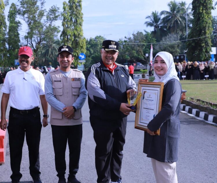 Wako Solok Wali Kota Solok, Zul Elfian saat menyerahkan piagam pada seorang peserta senam.