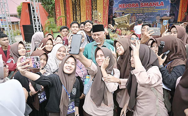 SWAFOTO— Siswi dan siswa SMAN 1 Lubuk Alung antusias berswafoto dengan Gubernur Sumbar, Mahyeldi Ansharullah, beberapa waktu lalu.