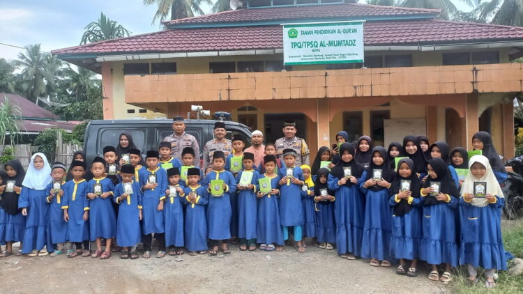 BAGIKAN AL QURAN— Kasat Binmas Polres Sijunjung, AKP  Yuliza Herman usai bagikan  Al-Quran dan Buku Iqra foto bersama dengan para santri.