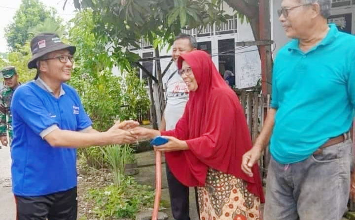 GOTONG ROYONG— Wali Kota Padang Hendri Septa menyalami warga yang sedang melaksanakan gotong royong membersihkan pekarangan rumahnya masing-masing melalui program “Padang Bagoro”.